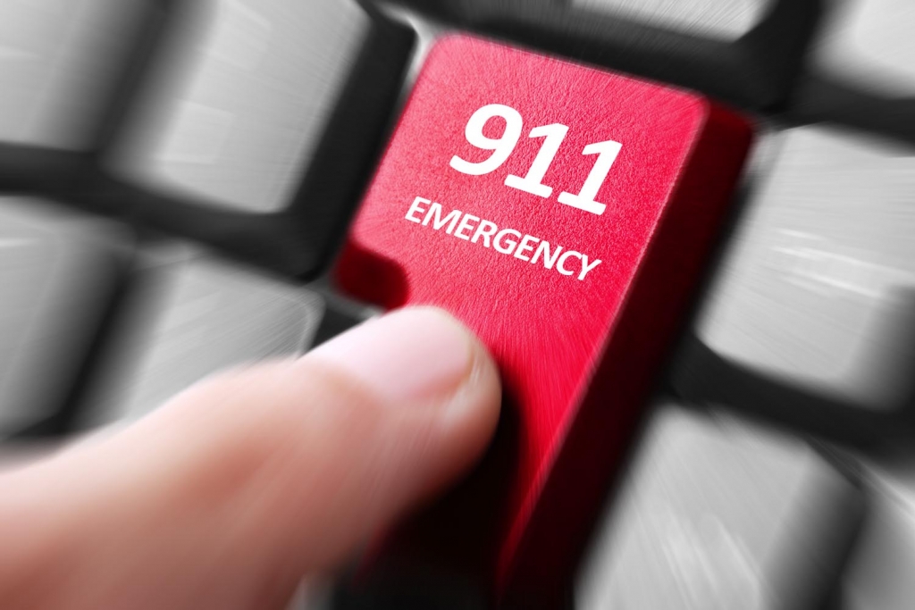 Finger on 911 Emergency red key on keyboard.