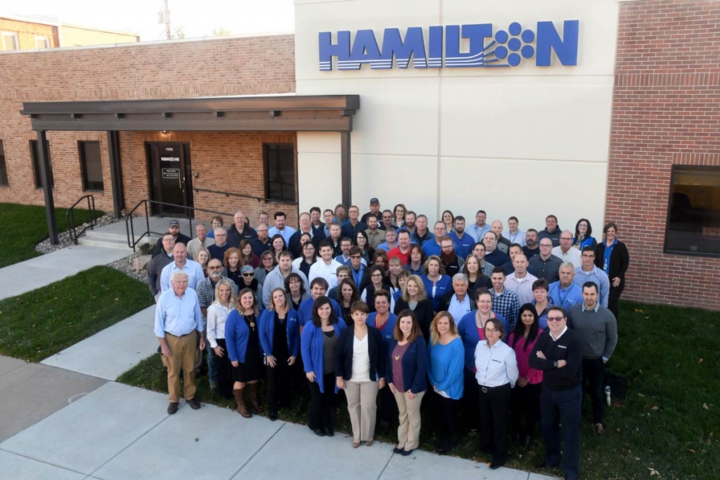 Team photo in front of the Hamilton corporate building in Aurora, NE.