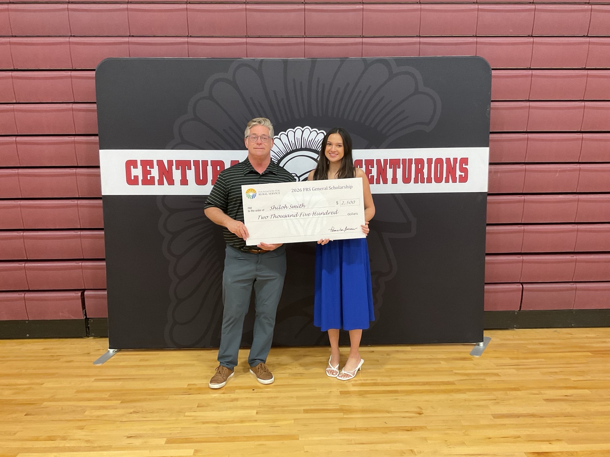 Hamilton employee awarding scholarship to a student